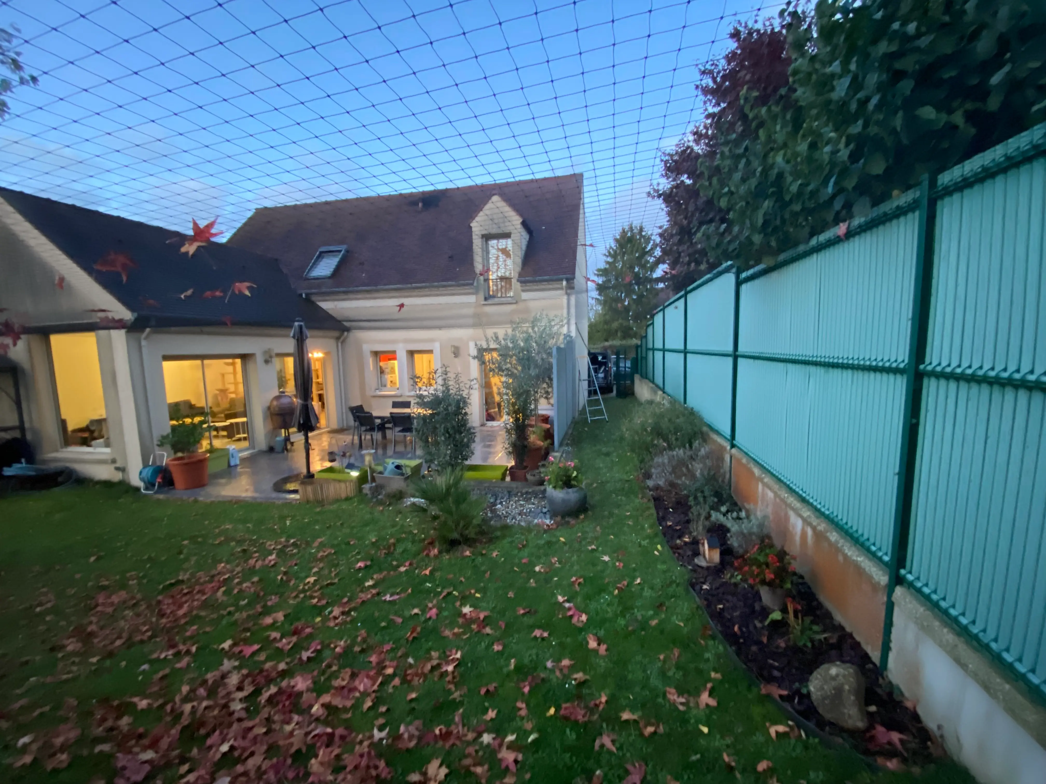 Filet aérien installé autour d’une clôture de jardin pour sécuriser un chat