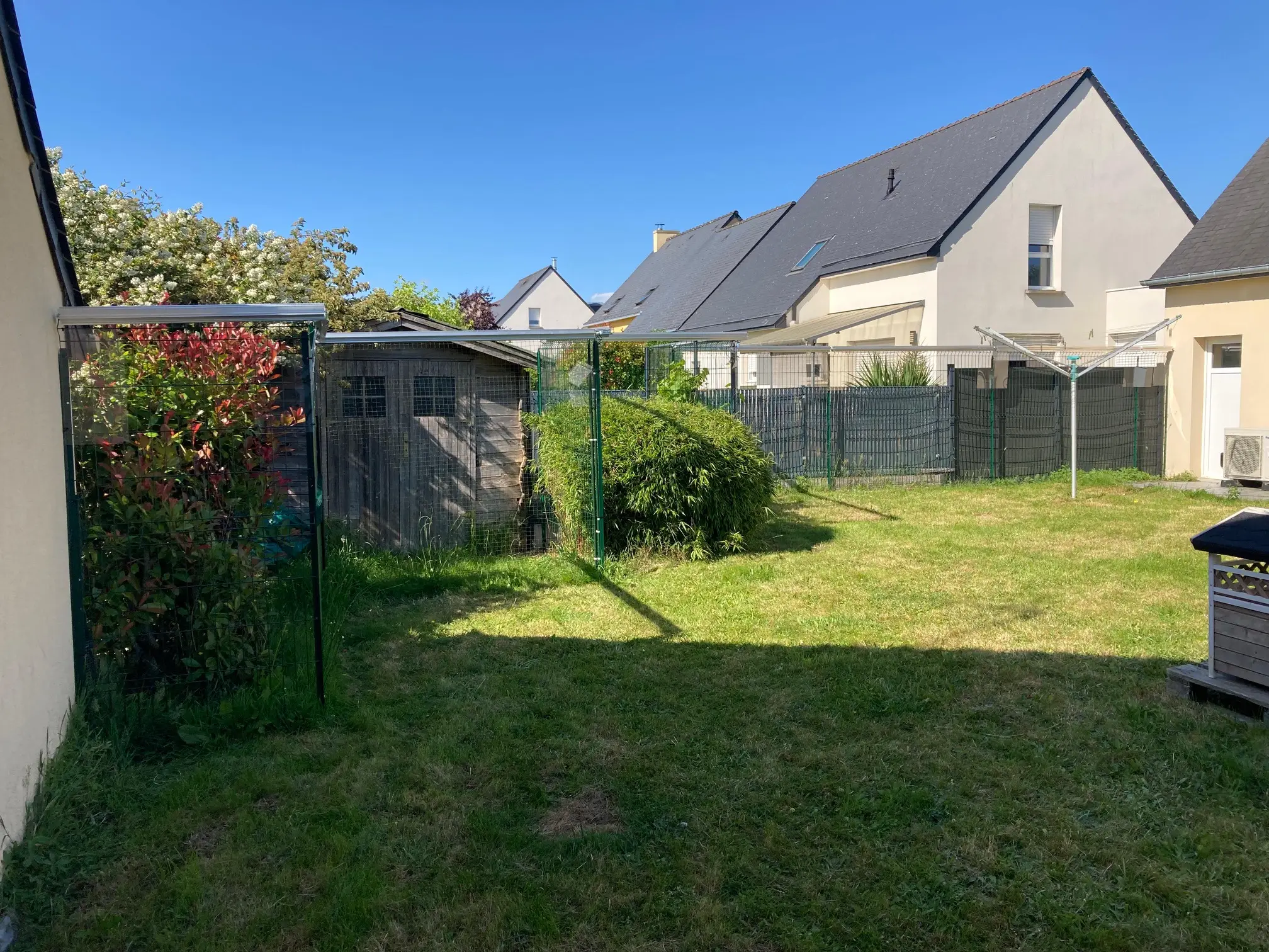 Rouleau anti fugue pour chat installé au sommet d’une clôture de jardin