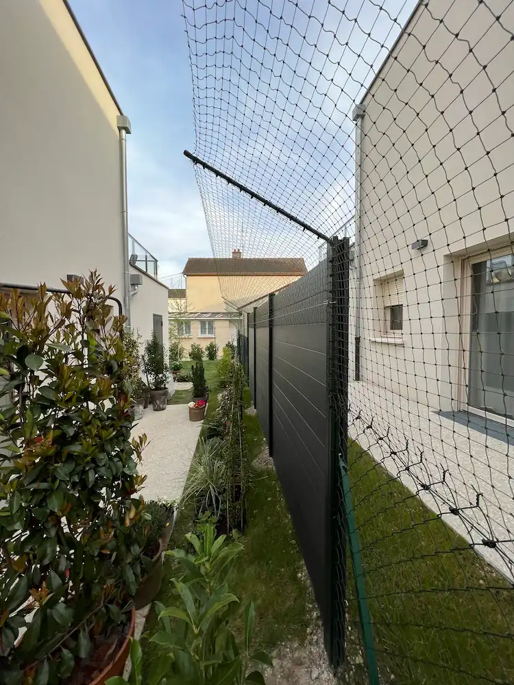 Bavolet anti fugue fixé sur une clôture grillagée pour chat