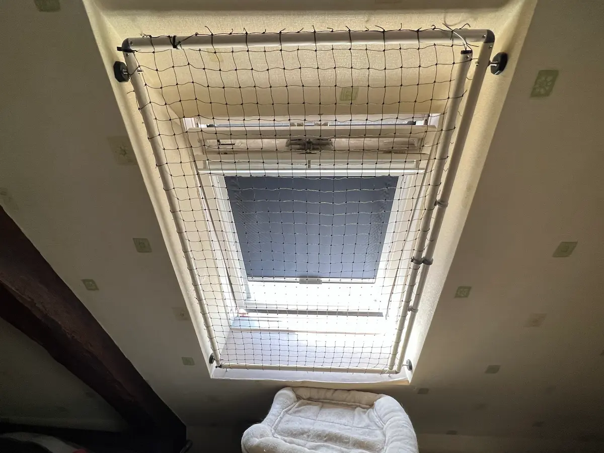 Bavolet anti fugue fixé sur une clôture grillagée pour chat