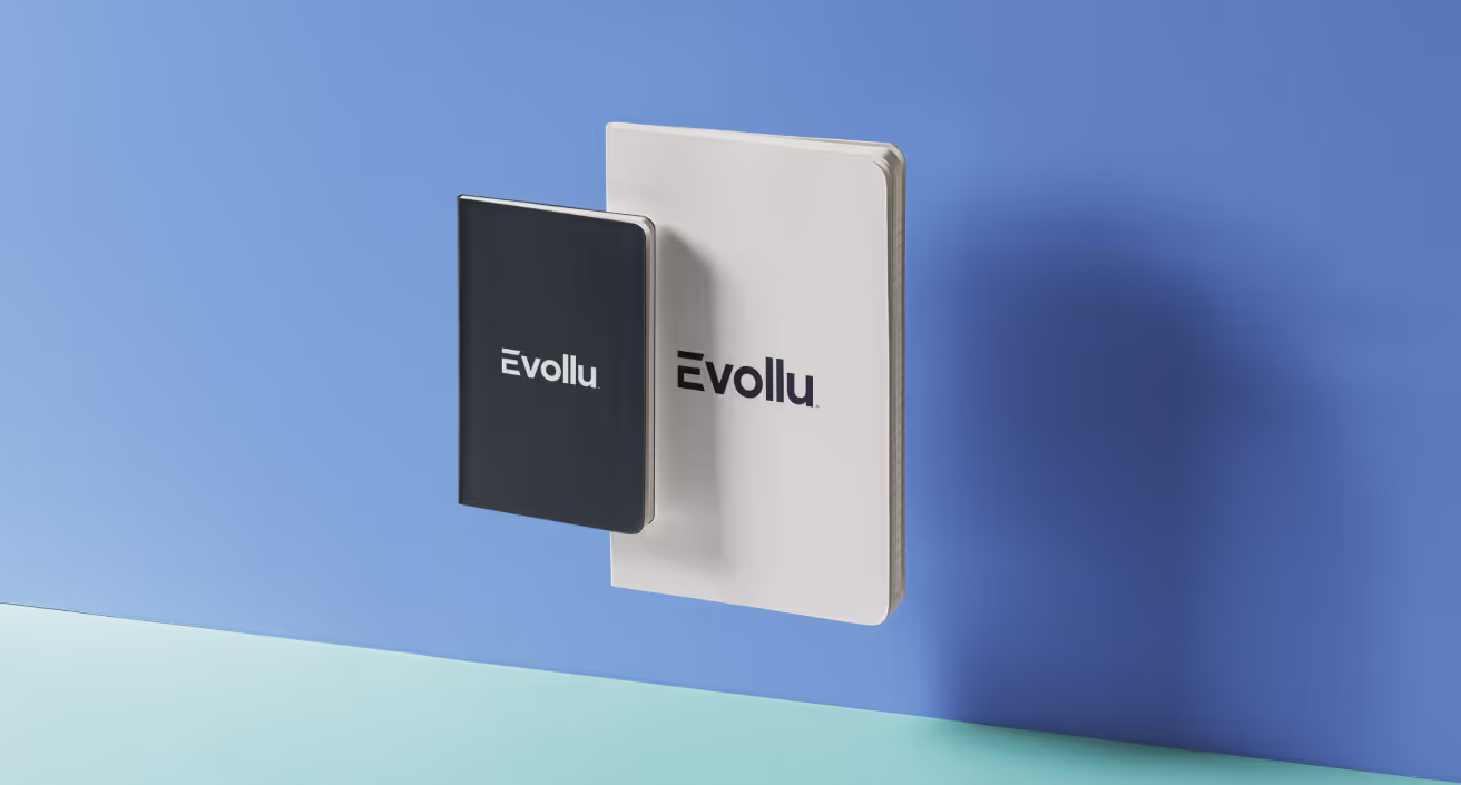 Evollu logo in black and white on two white and black paper notebooks.