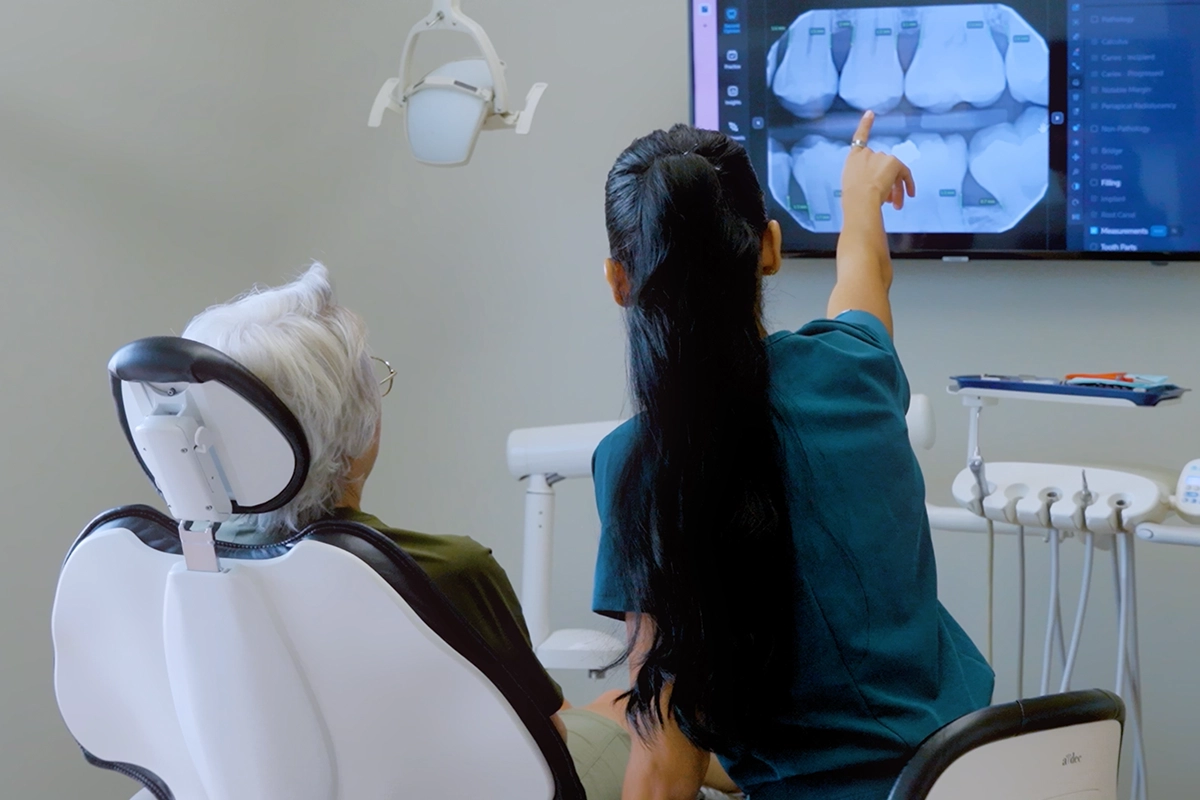 Dental hygienist showing a patient an area of tooth decay on a digital dental X-ray at Alpers Dentistry in Scottsdale, AZ.