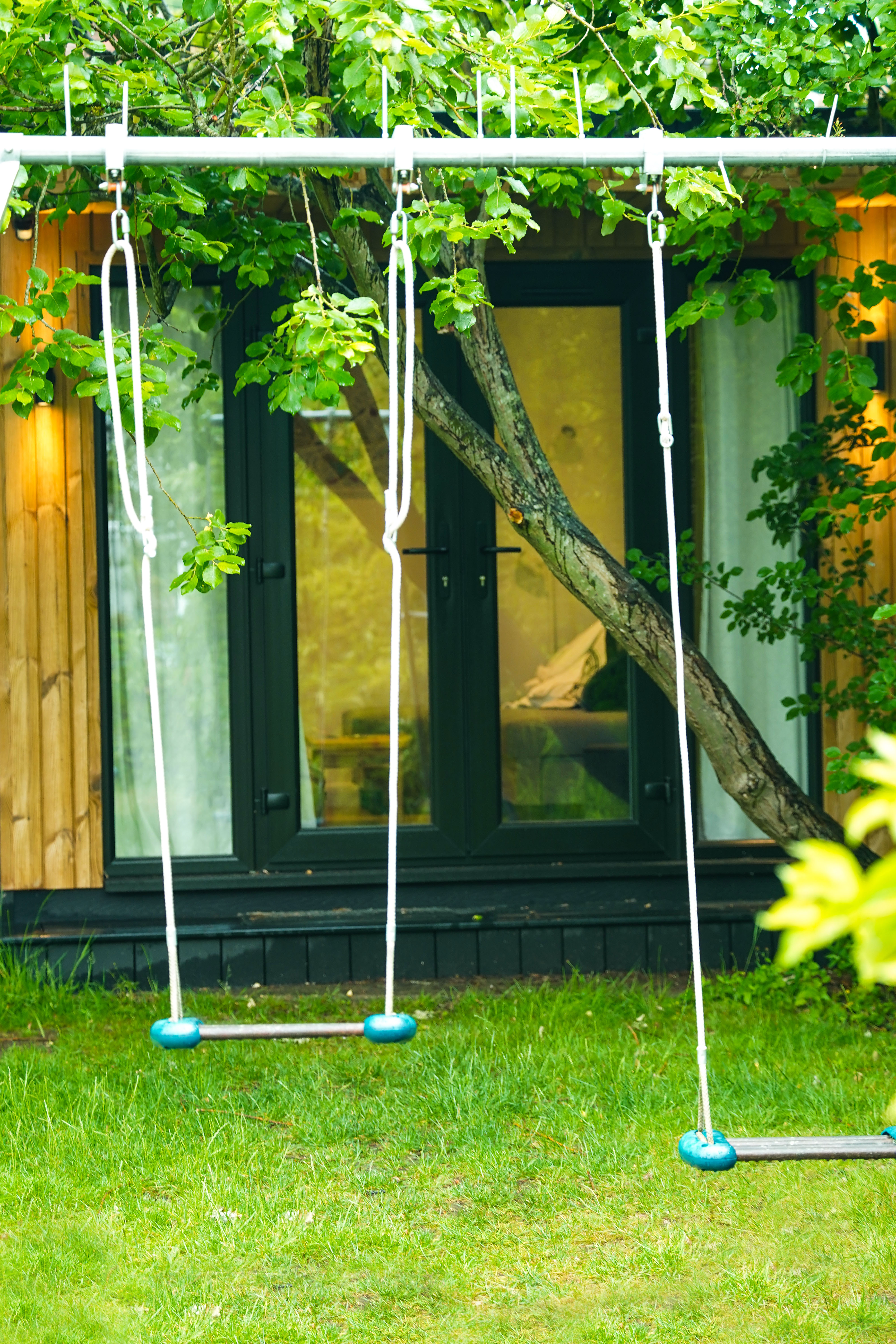 Swing set in front of a garden room in autumn