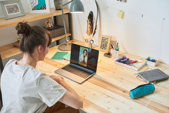 Une jeune femme utilise un ordinateur portable pour passer un appel vidéo.