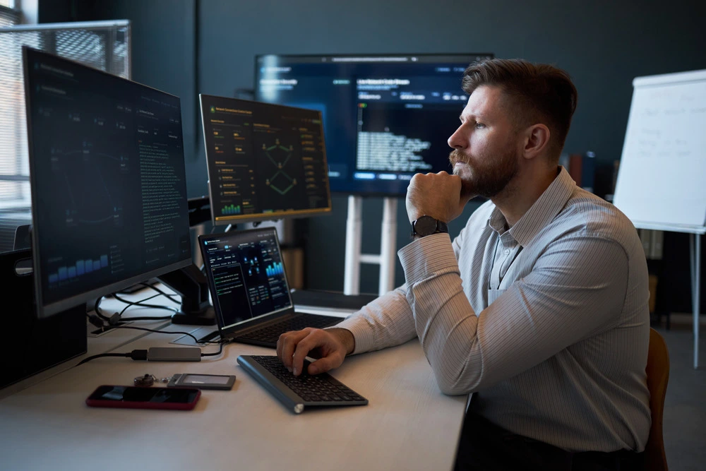 Cloud professional working with multiple technical monitoring screens