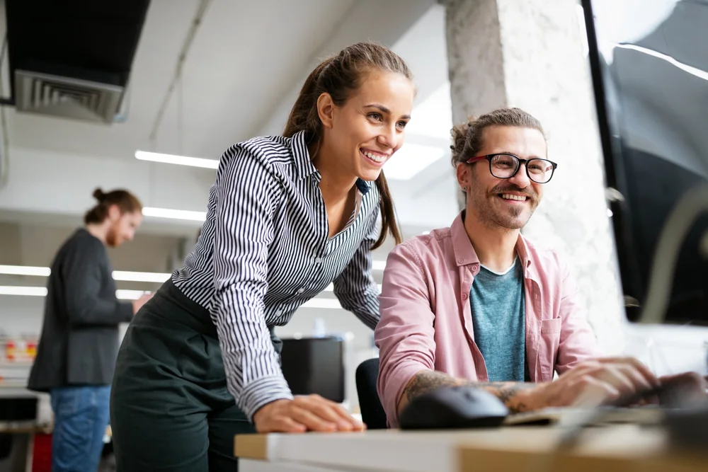 Colleagues collaborating at an IT workstation