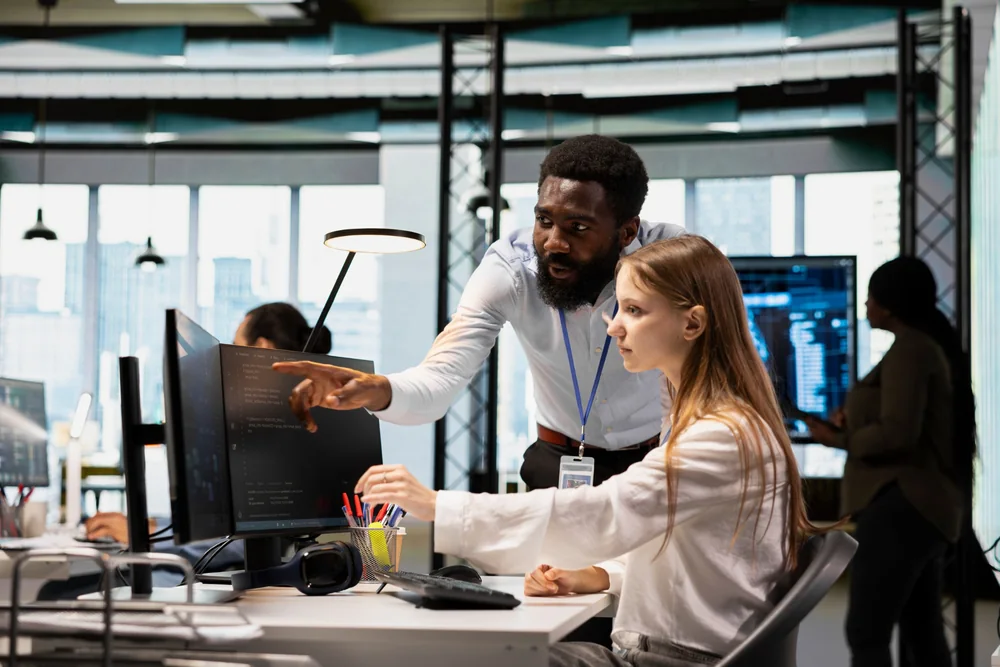 IT professionals collaborating around technical monitoring screens