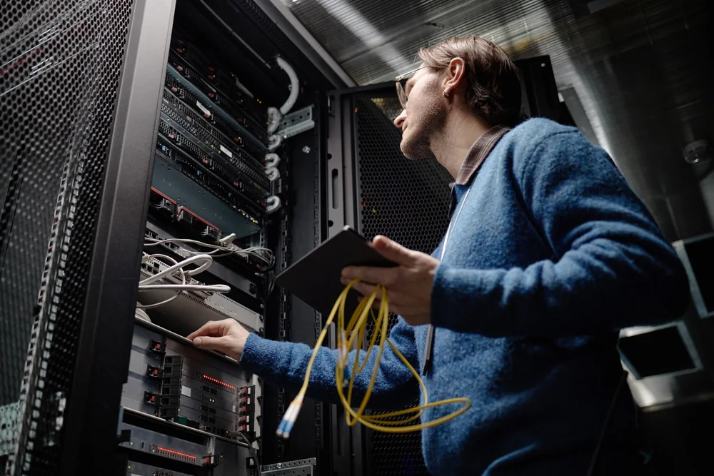 Network technician working with data centre server racks