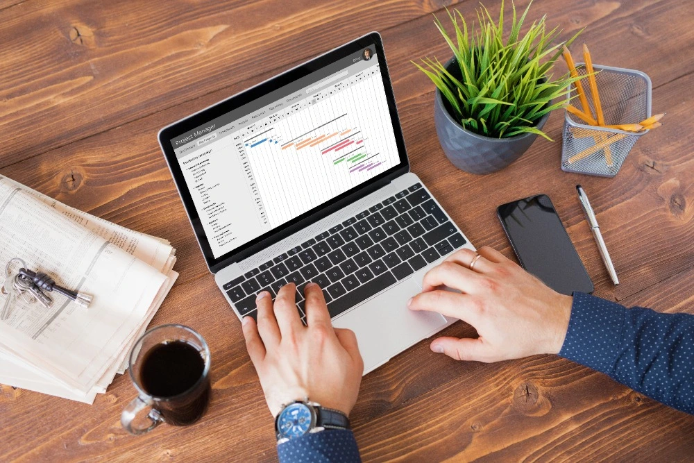 A person using Microsoft Project on a laptop