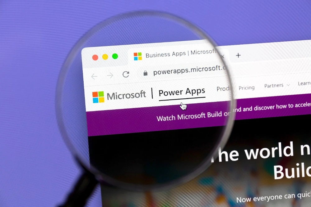 A photo of a magnifying glass hovering over the Microsoft Power Apps application window