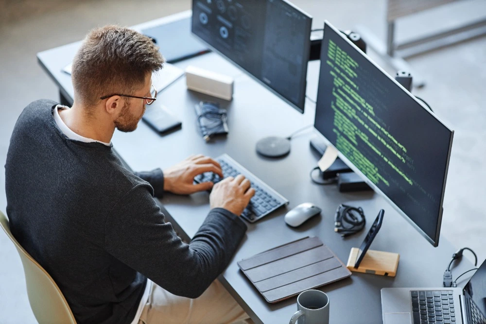 A photo of a man programming on a laptop