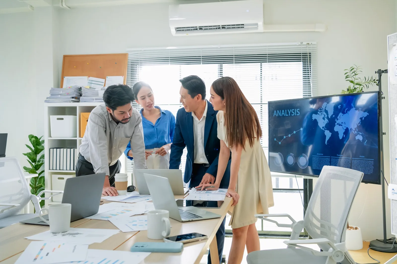 Business professionals analysing data together at computer screens