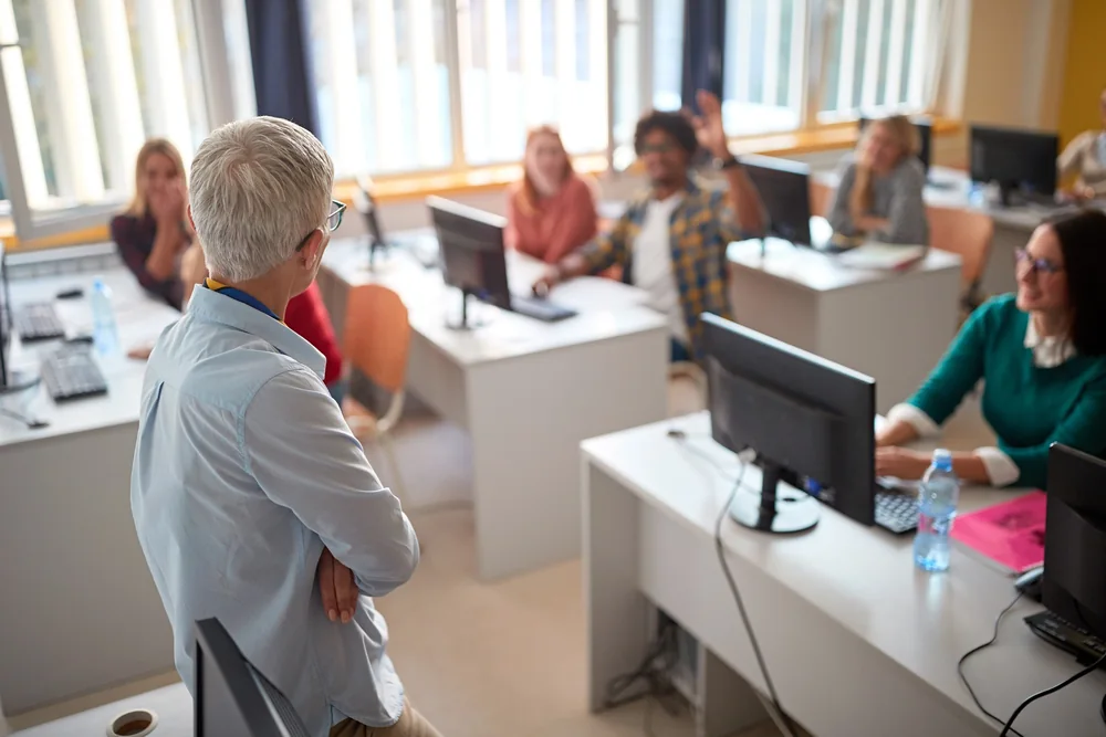 Instructor-led computer training session with adult learners at desktop computers