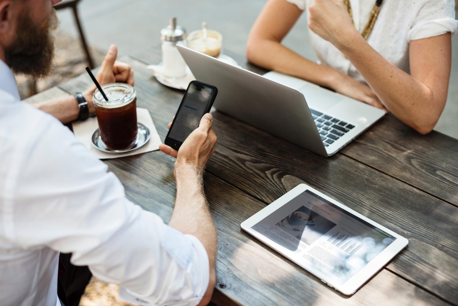 Business professionals working together with a laptop, tablet and mobile device