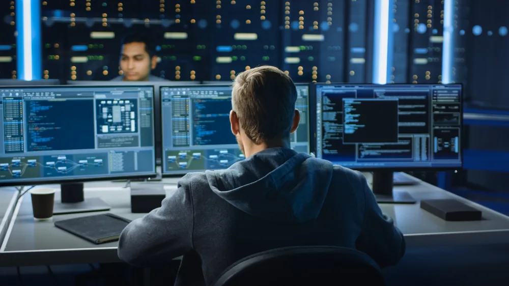 Cyber security analysts monitoring systems across multiple screens in a security operations centre