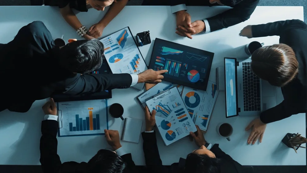 Business and technical team analysing energy and performance data on digital dashboards