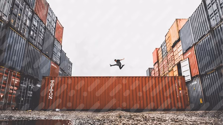 Homem no meio de vários containers de importação.