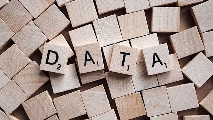 Vários blocos de madeira com letras, com destaque para 4 blocos que formam a palavra "data", dados em inglês.