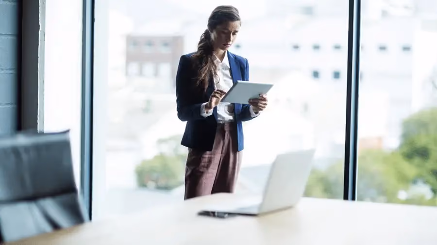 Mulher em um escritório, segurando um relatório e expressando preocupação.