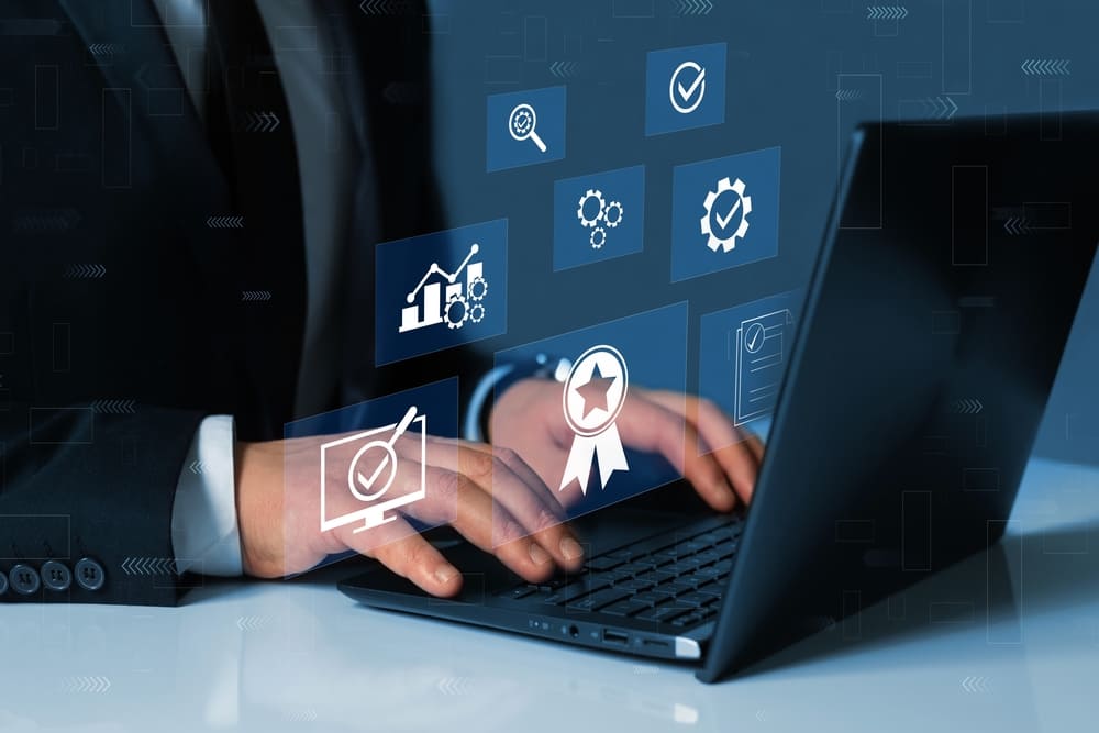 Empresário digitando no notebook, com ícones digitais em 3D sobre a tela representando o banco de dados do número DUNS