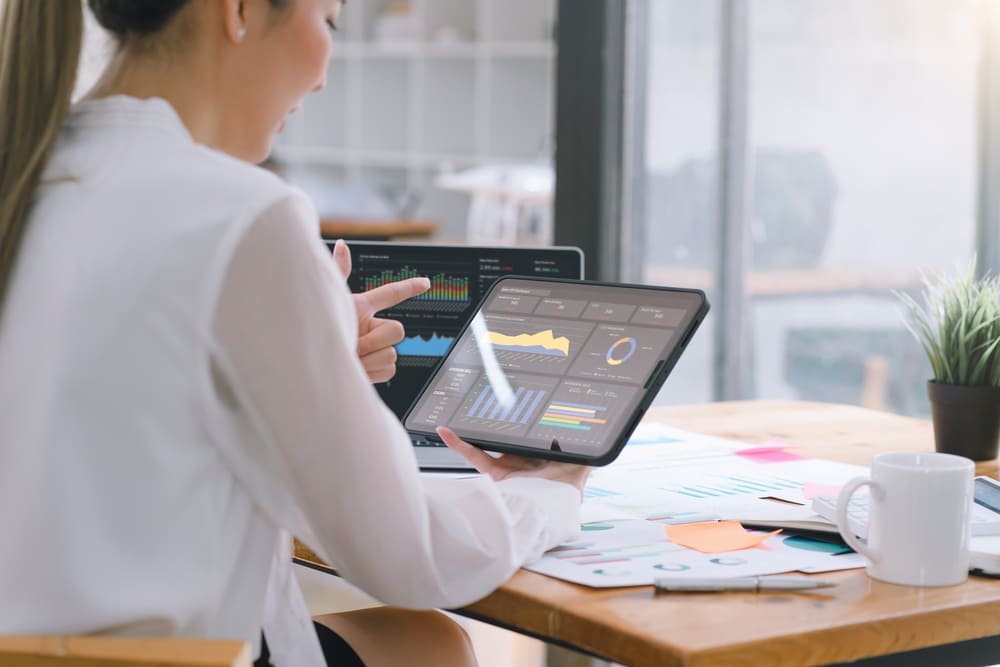 Mulher avaliando gráficos e dados para realizar o diligenciamento de processos na empresa
