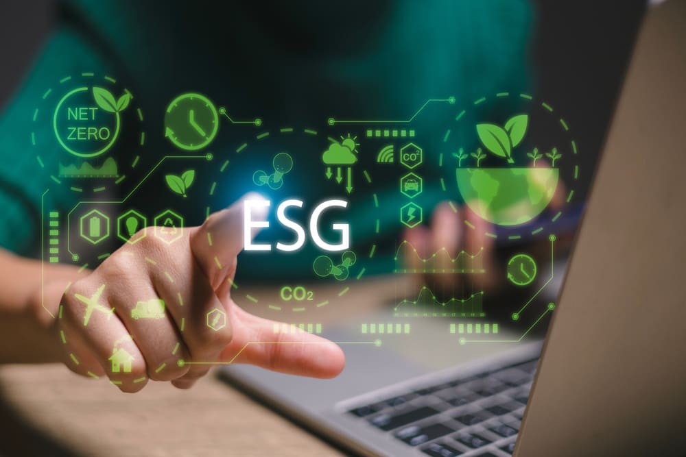 Pessoa utilizando notebook com ilustração 3D na tela mostrando ícones relacionados à certificação ESG