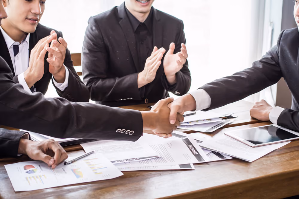 Aperto de mãos entre executivos durante reunião de alinhamento da gestão de stakeholders