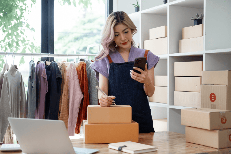 Uma mulher feliz enviando suas caixas ela está tendo um bom relacionamento com seu fornecedor