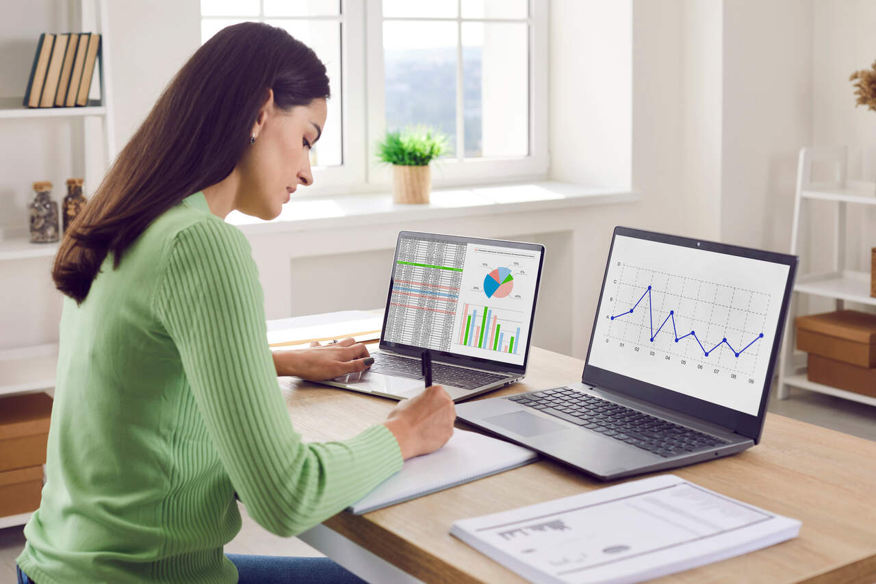 Profissional analisando relatórios financeiros e dashboards de desempenho em notebooks, com foco em análise de dados, gestão financeira e acompanhamento de pagamentos.
