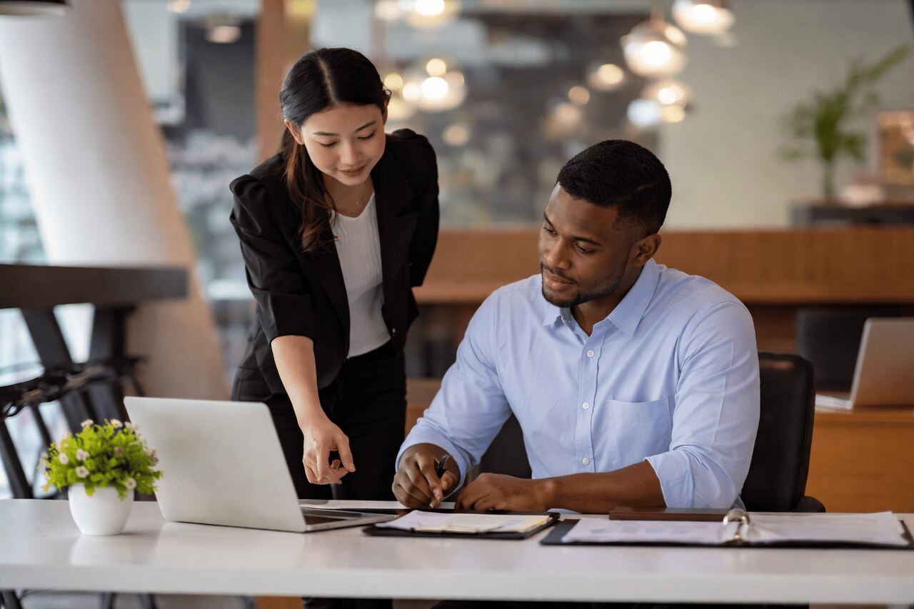Mulher e homem revisando contrato digital em tablet, representando processo de gestão de contratos em um ambiente corporativo