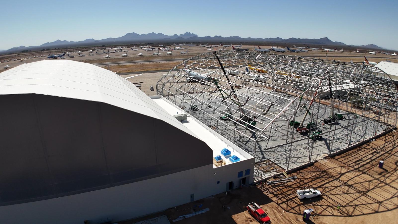 The finished hangar beside the bare frame of its twin