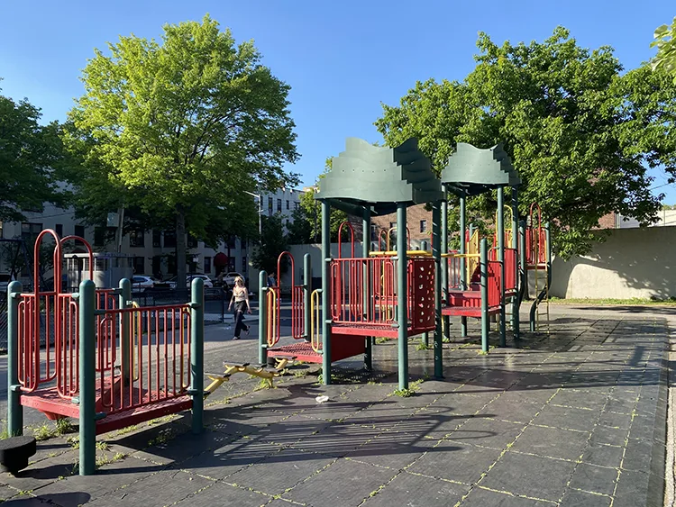 The red portion of the playground is linear in play format with monkey bars connecting sections