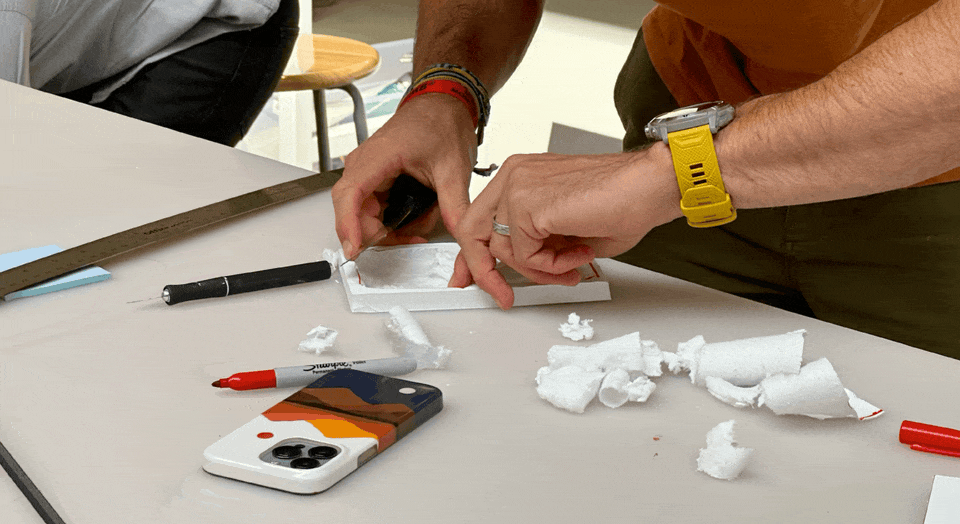 Photo of a person creating a prototype out of foam core with animated highlights.
