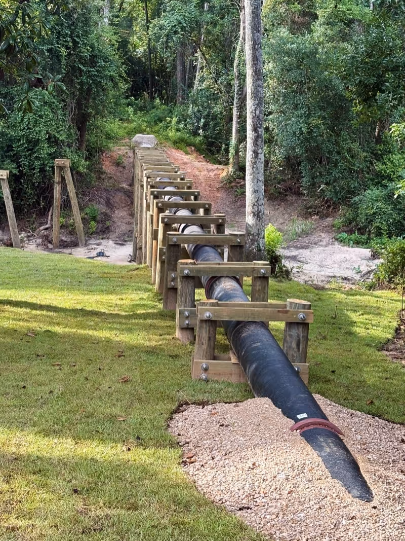 An iron pipe above ground with wooden scaffolding