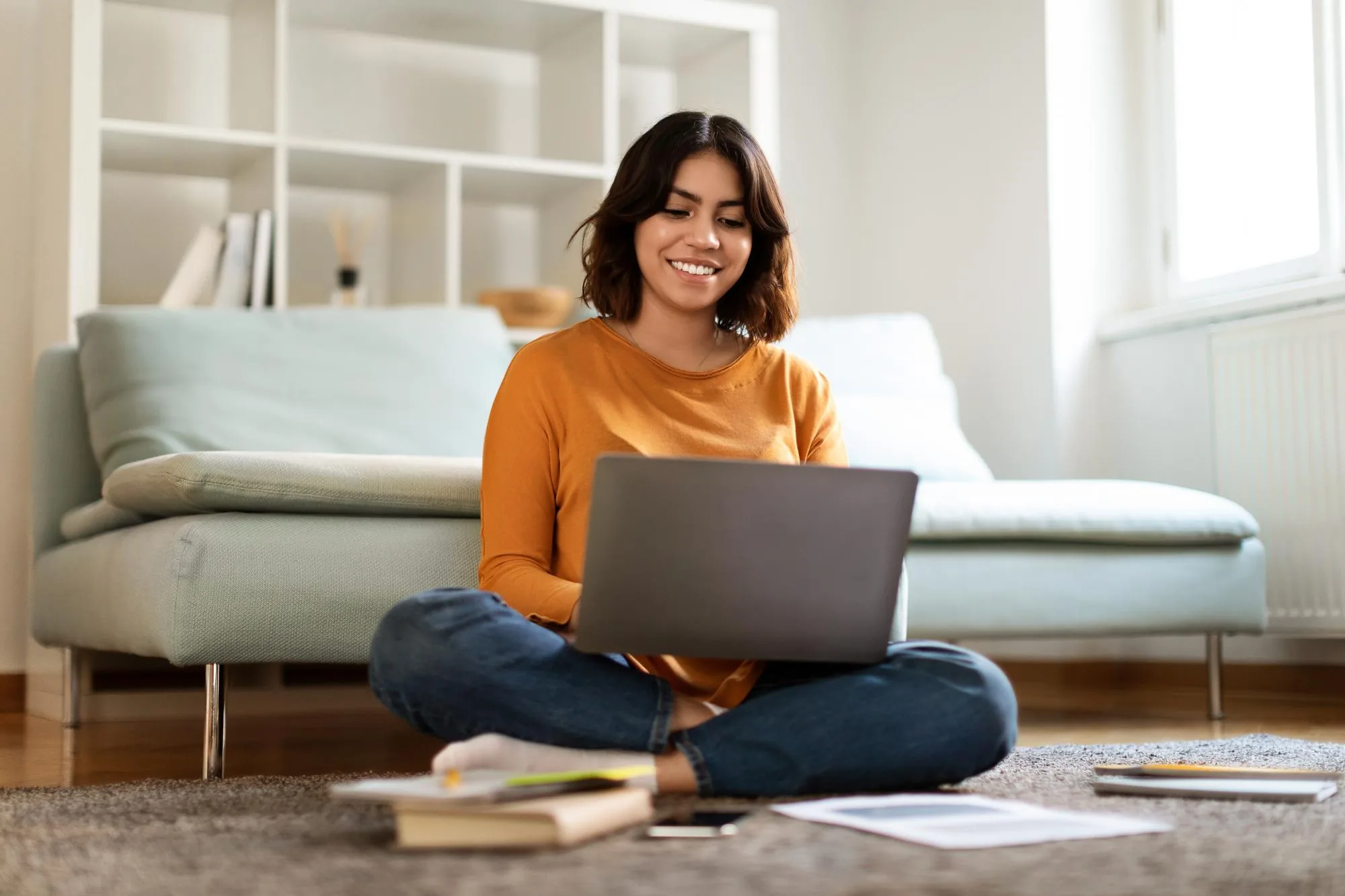 Pessoa sorrindo enquanto estuda no computador