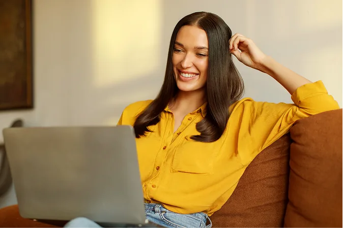 Pessoa sorrindo enquanto usa o notebook