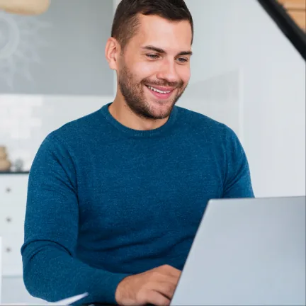 Pessoa sorrindo enquanto estuda no notebook