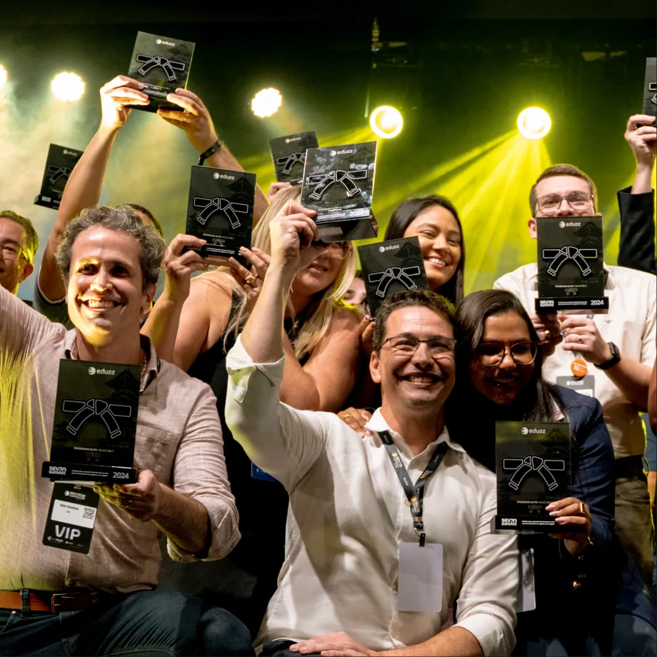 Grupo erguendo as placas do programa Elite em um evento da Eduzz