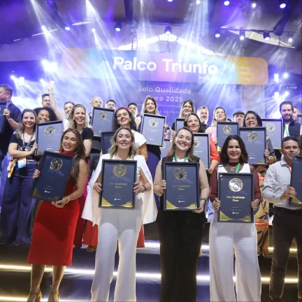 Grupo no palco segurando os selos de qualidade