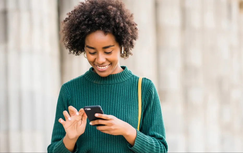 Mulher sorrindo enquanto olha o celular