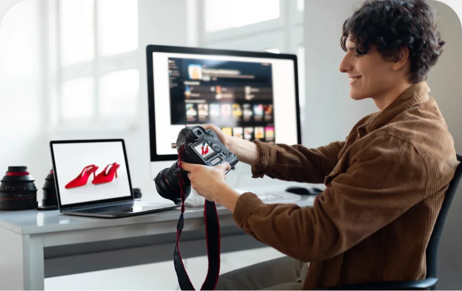 Homem editando vídeo em dois monitores, com uma câmera sobre a mesa