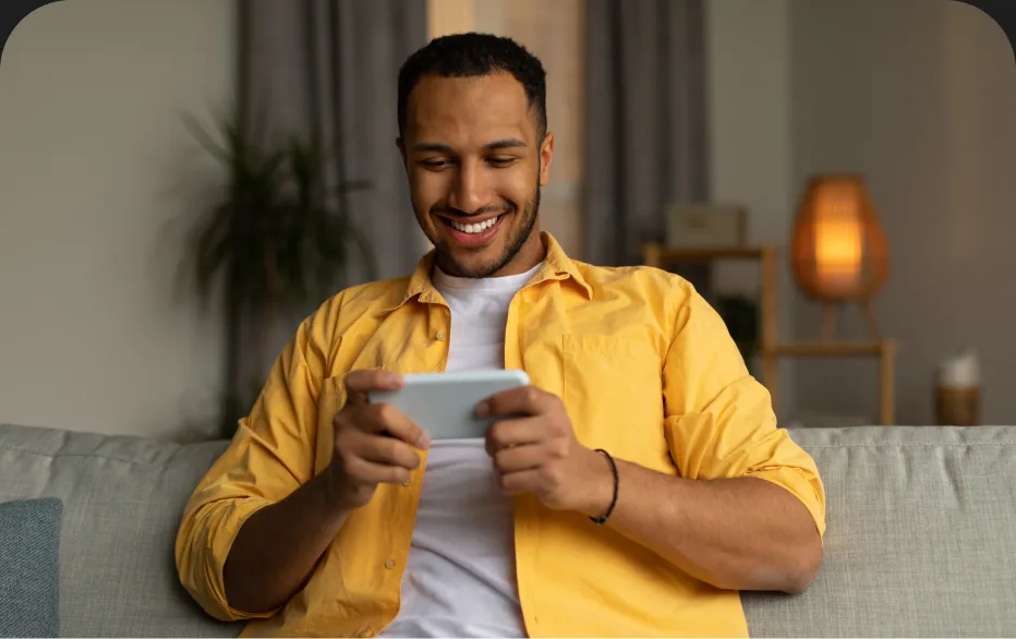 Homem de jaqueta amarela assistindo a um vídeo no celular