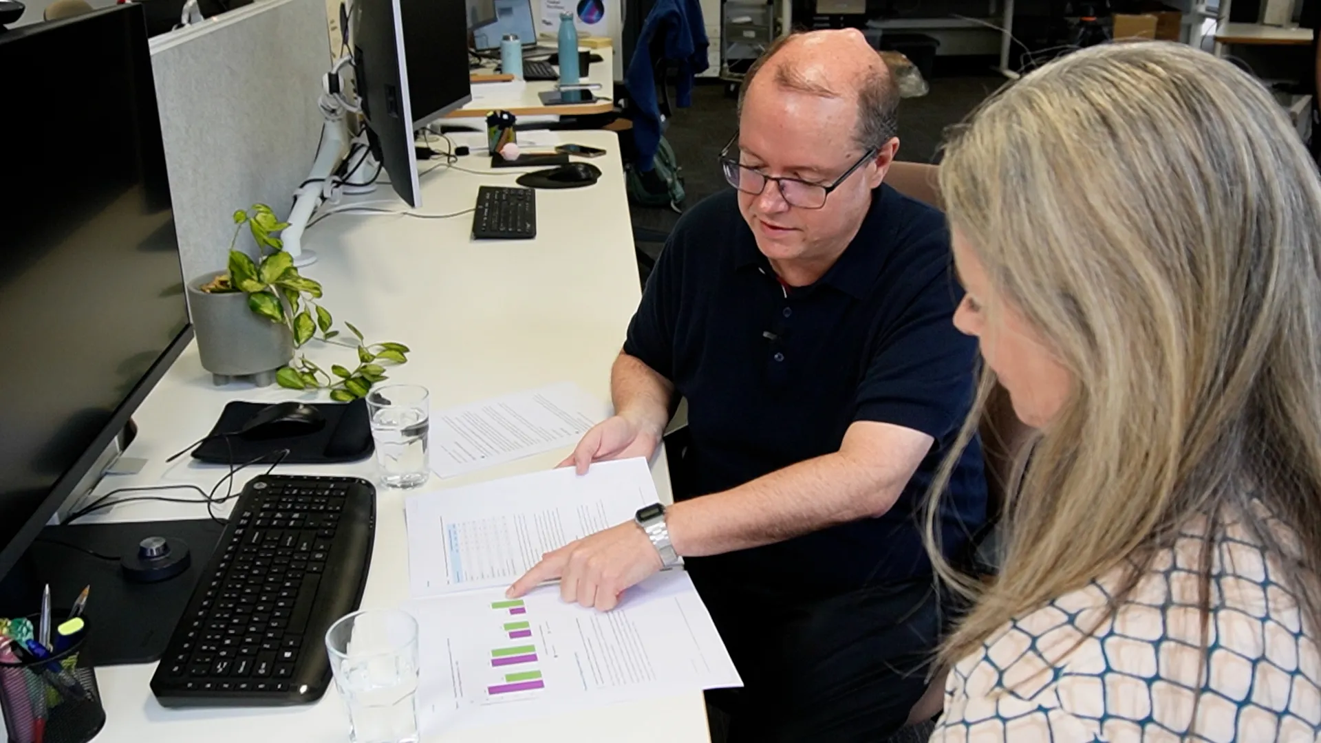 Research Director Dr Hugh McDonald and Grants Director Melanie Rygl reading through a printed copy of the Justice at a disadvantage short paper at a desk in the VLF office.