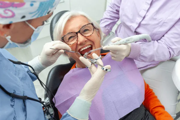 implantacja-natychmiastowa-pacjentka-na-fotelu-stomatologicznym-podczas-zabiegu