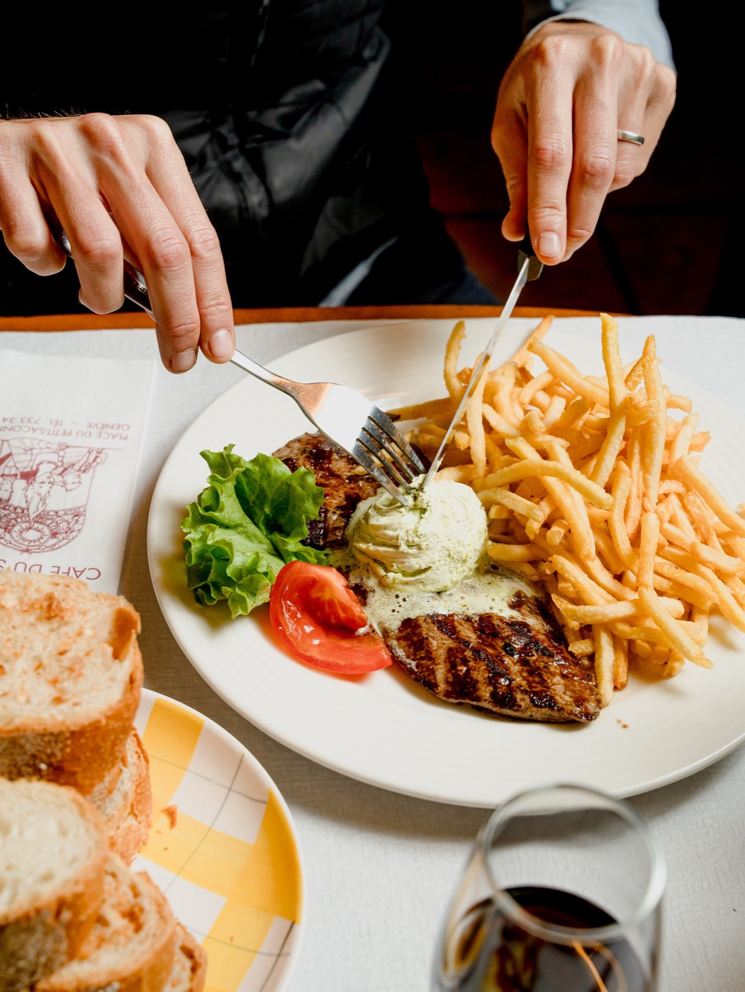Une assiette de viande, beurre aux herbes et frites au Café du Soleil