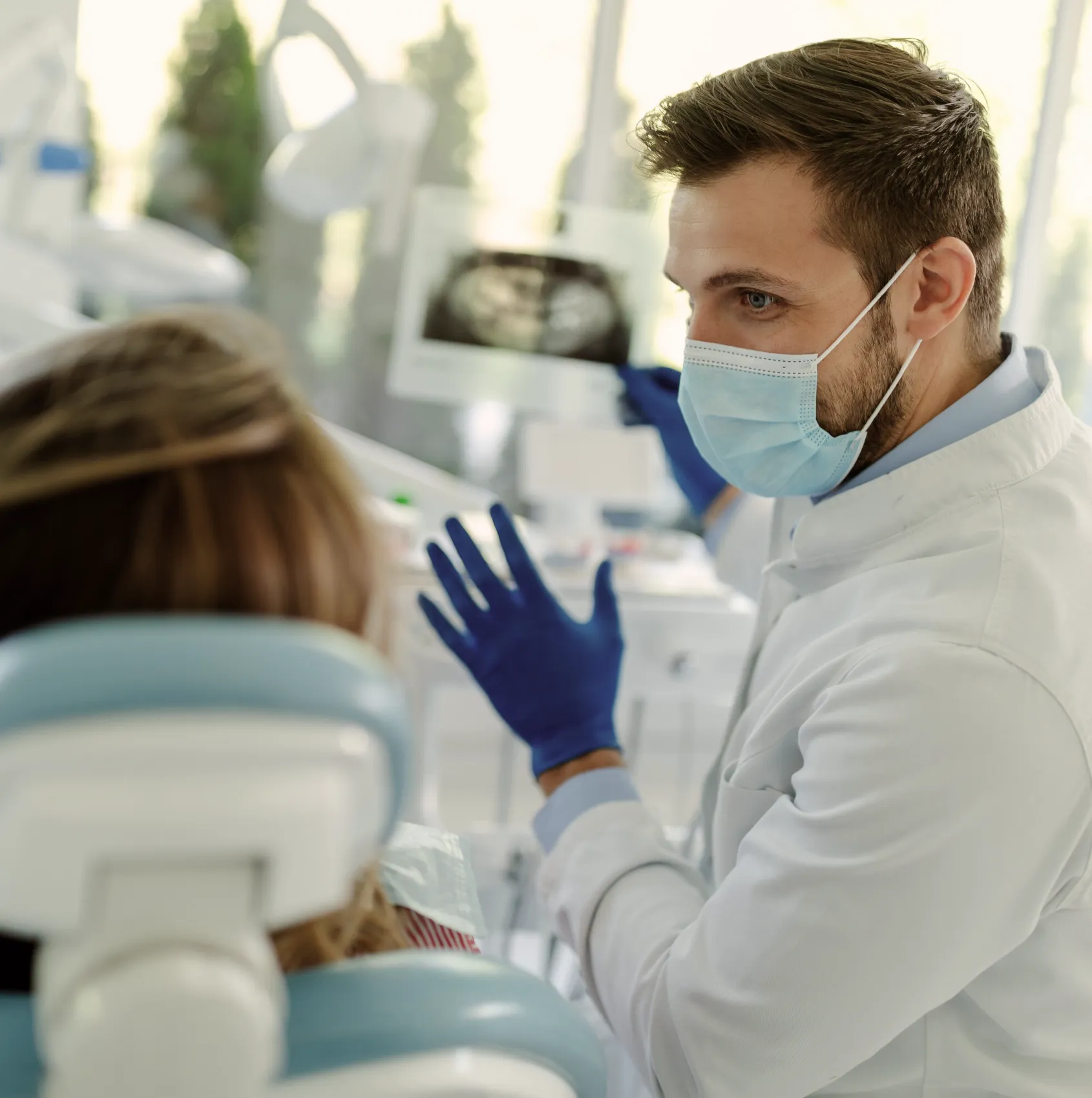a man in a white lab coat and blue gloves