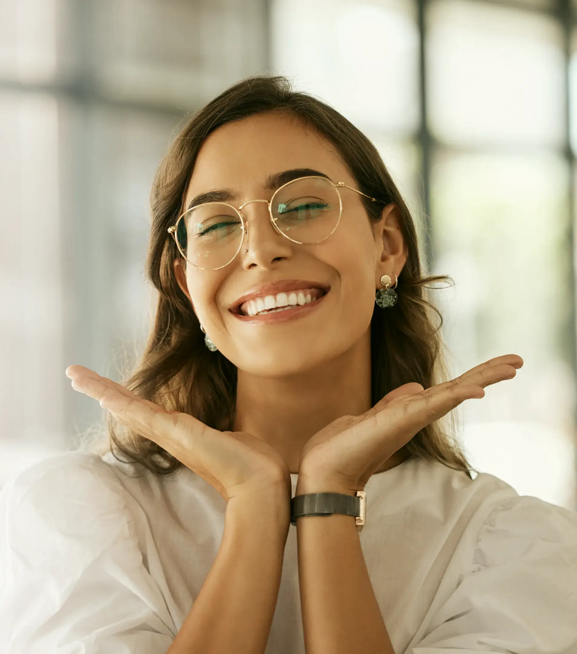 a woman wearing glasses making a gesture with her hands