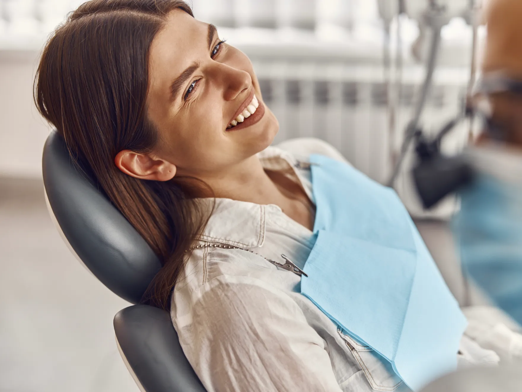 a woman sitting in a dentist chair smiling