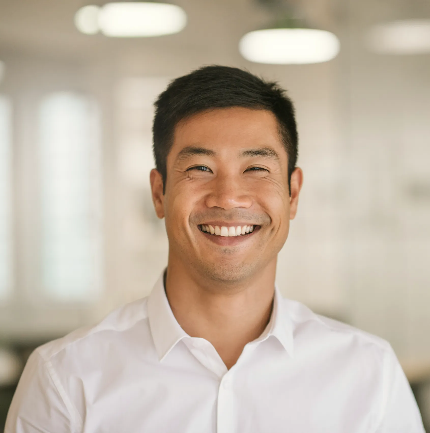 a man in a white shirt smiling for the camera