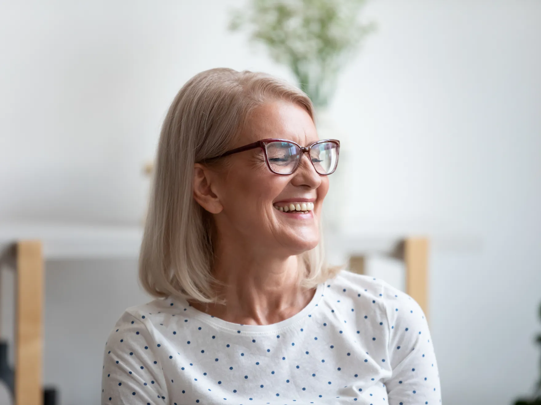 a woman with glasses smiling at the camera